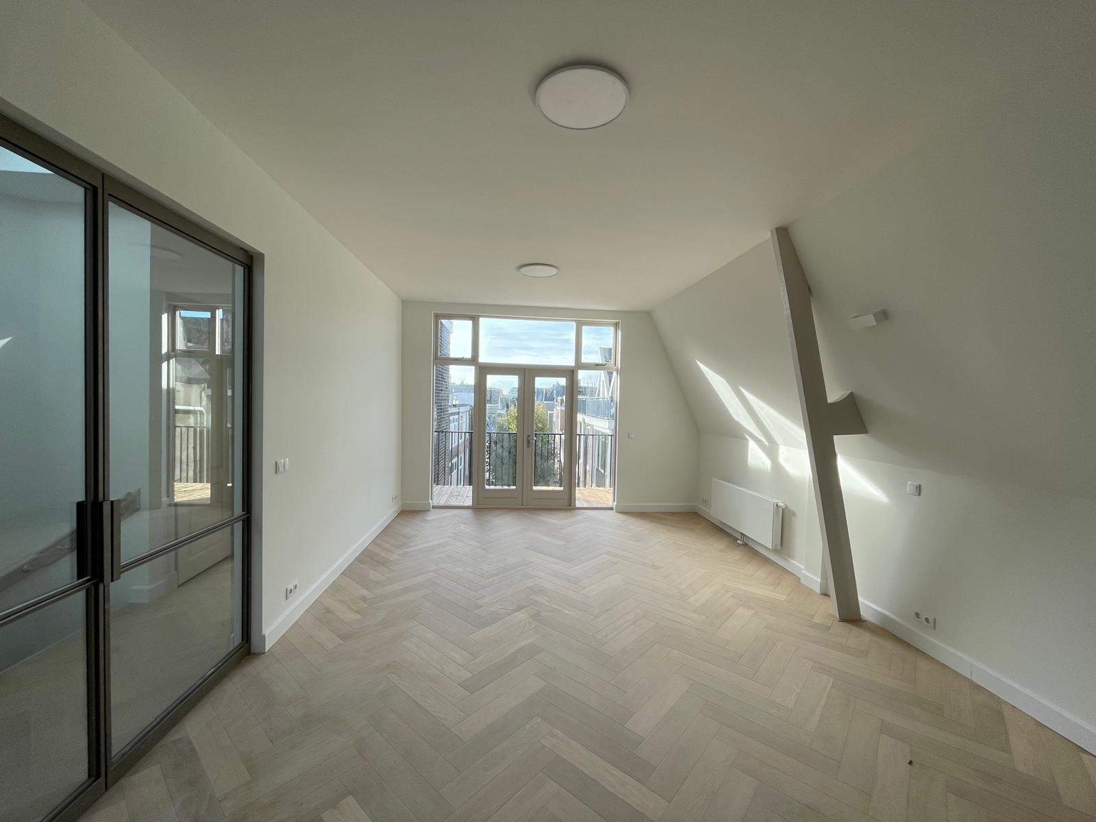 Renovated roof apartment in the Agniesebuurt with herringbone floor and steel pivot doors