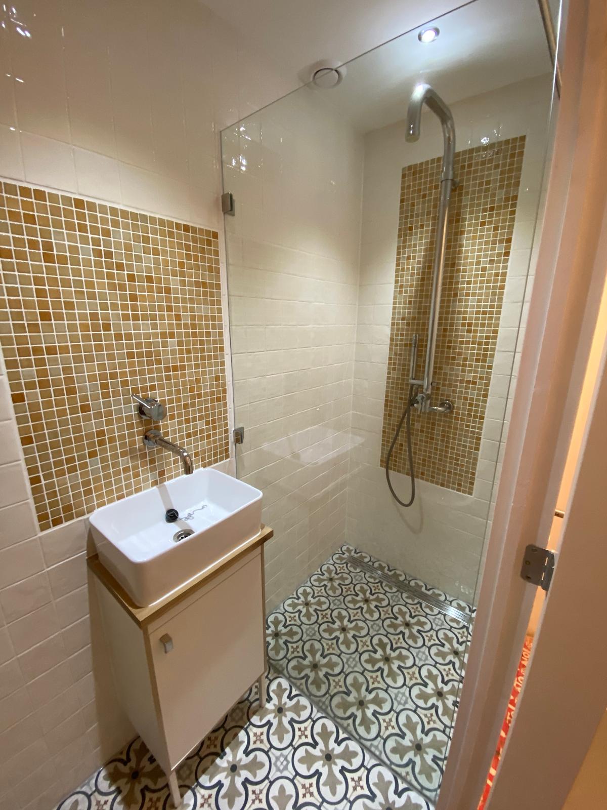Corner basin and mosaic wall in a toilet under the stairs in Kralingen