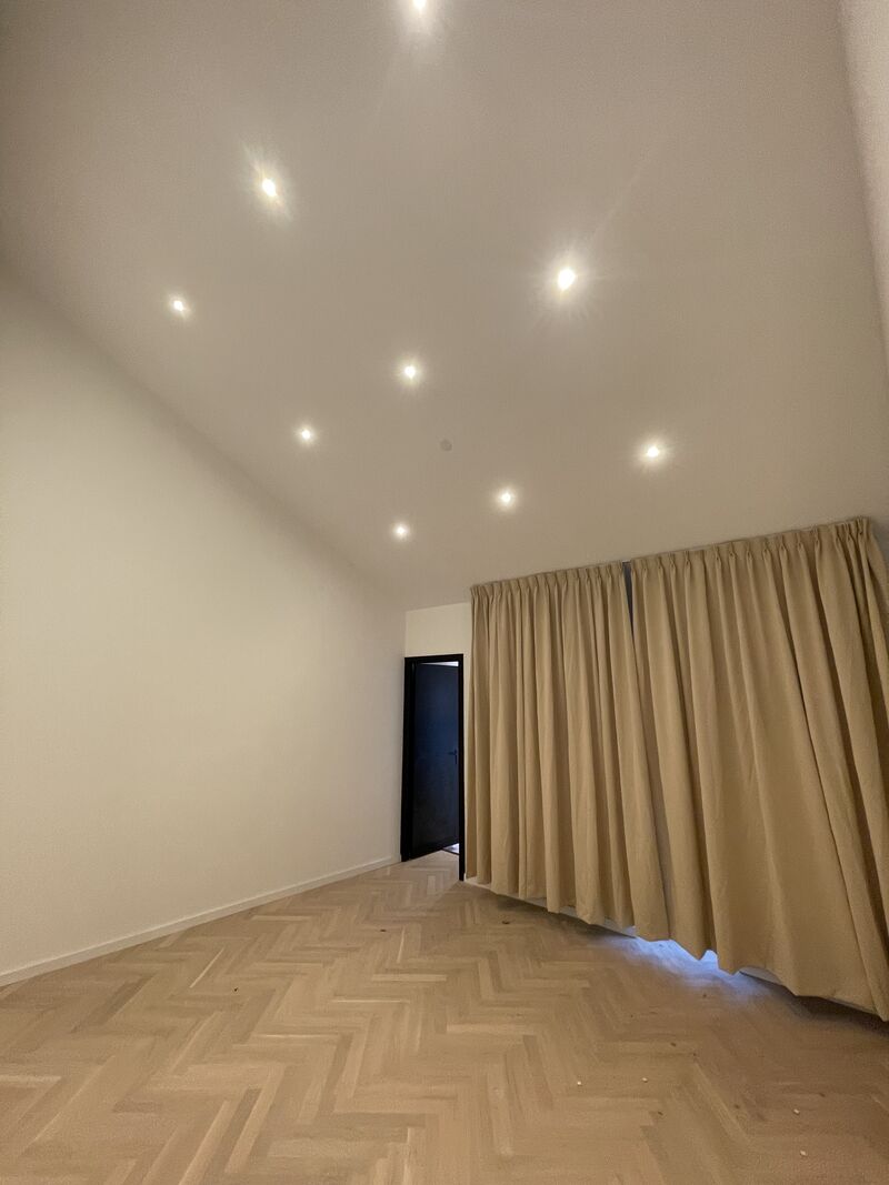 Ruime kamer met hoog plafond en visgraatvloer na renovatie, Den Haag