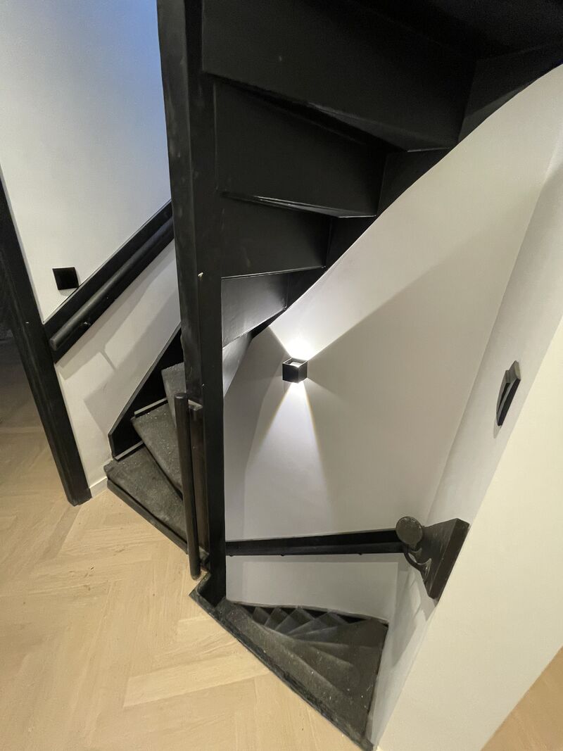 Gerenoveerde trap met zwarte treden in de woning die we in Den Haag-Centrum verbouwden