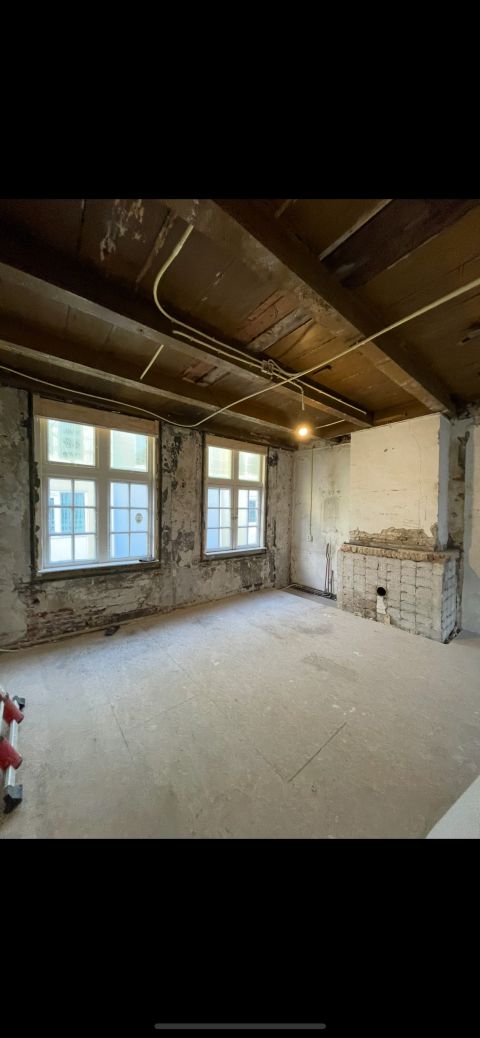 Gestripte verdieping met blootliggende balken, voor renovatie Den Haag