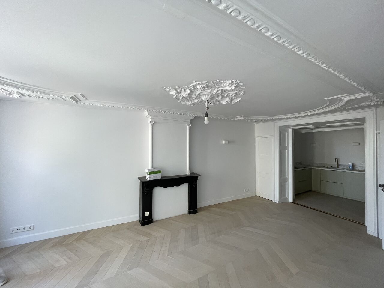 Neatly plastered ceiling with the original cornice and ceiling rose preserved, and smooth, paint-ready walls after renovation