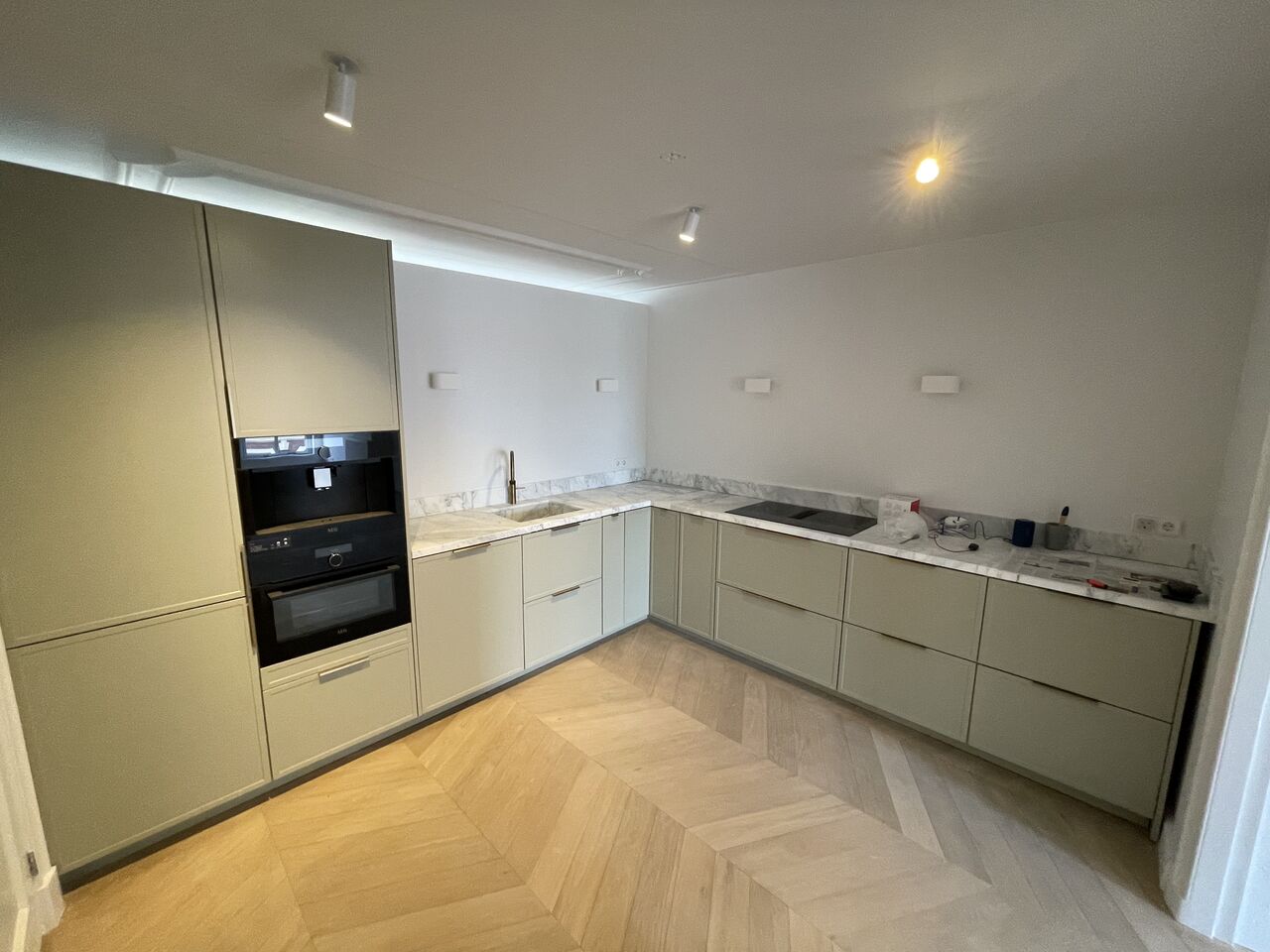 Turn-key opgeleverde maatwerkkeuken met marmer en visgraatvloer in een appartement in hartje Amsterdam