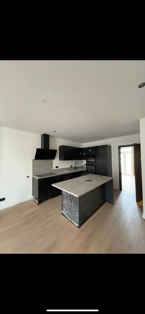 Zwarte keuken met betonlook werkblad in gerenoveerd appartement Korte Kade Rotterdam