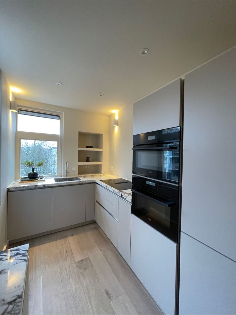 Nieuwe keuken met inbouwapparatuur en lichte fronten na een renovatie