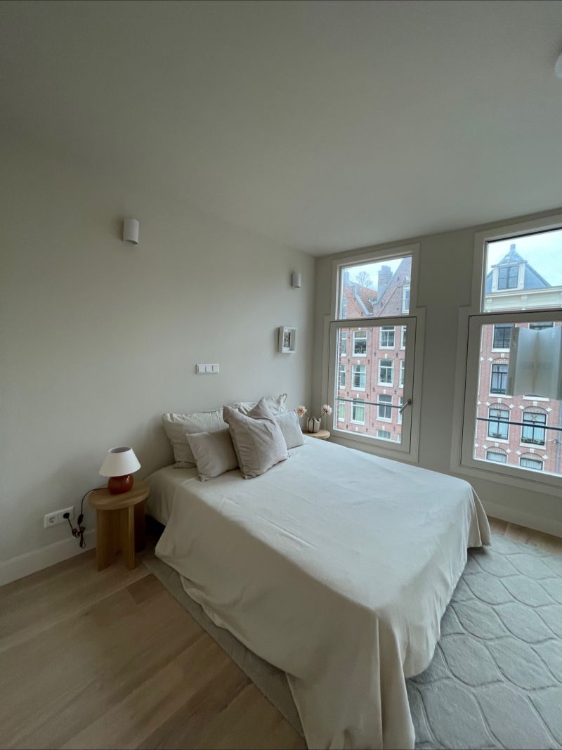 Lichte slaapkamer met twee hoge ramen na een renovatie