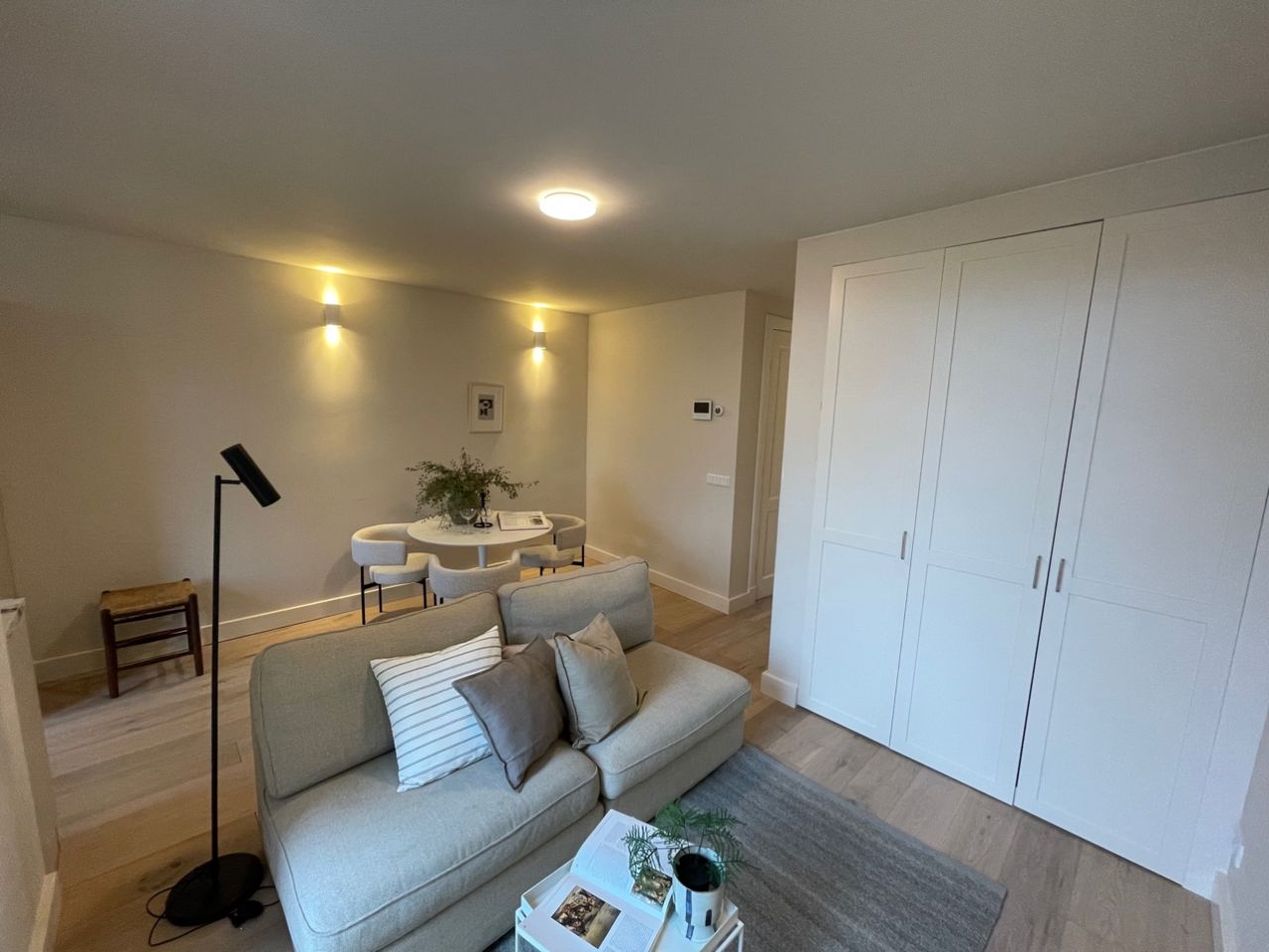 Ingerichte woonkamer met inbouwkasten en zithoek na een complete woningrenovatie