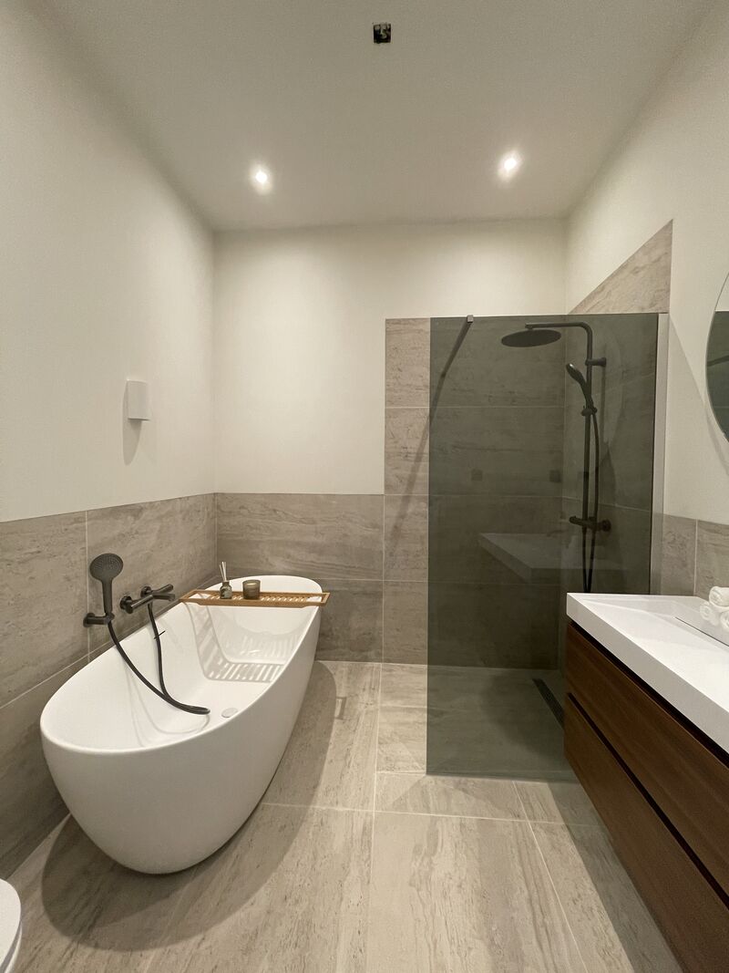 Complete bathroom renovation in Rotterdam with a freestanding bath, walk-in shower and floating wooden vanity unit