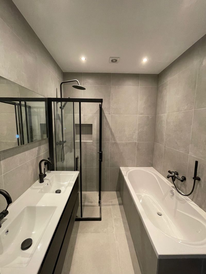 Nieuwe badkamer met ligbad en inloopdouche in een verbouwde woning aan de Zwartjanstraat in Rotterdam-Noord
