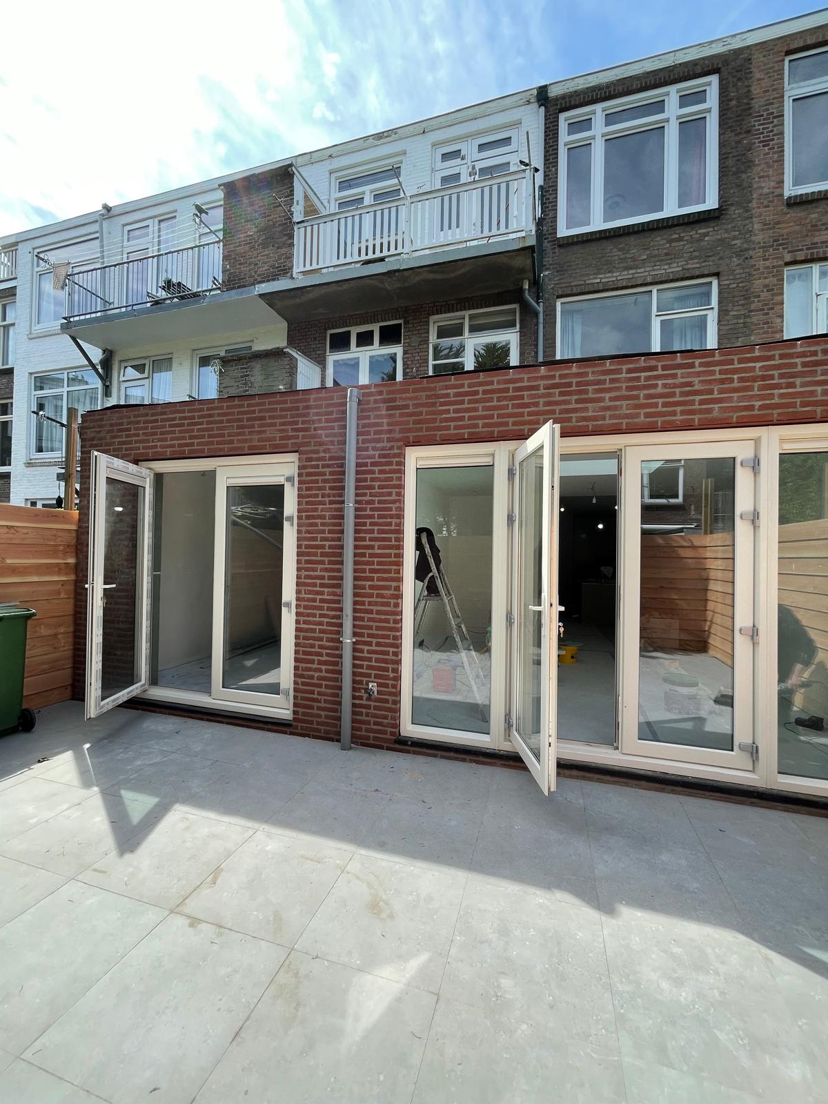 Aanbouw aan de tuinzijde met openslaande deuren over de volle breedte en een nieuw terras