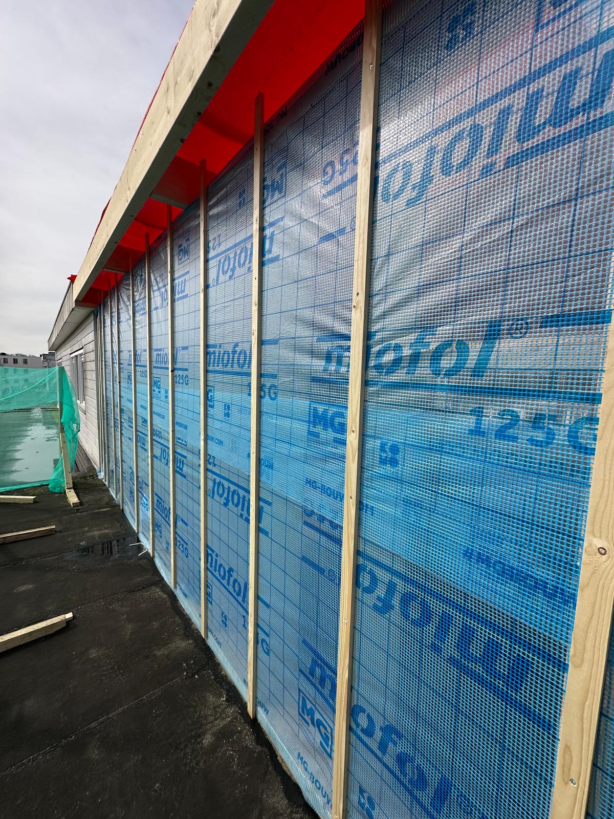 Wandopbouw van de dakopbouw met dampscherm en houten regelwerk